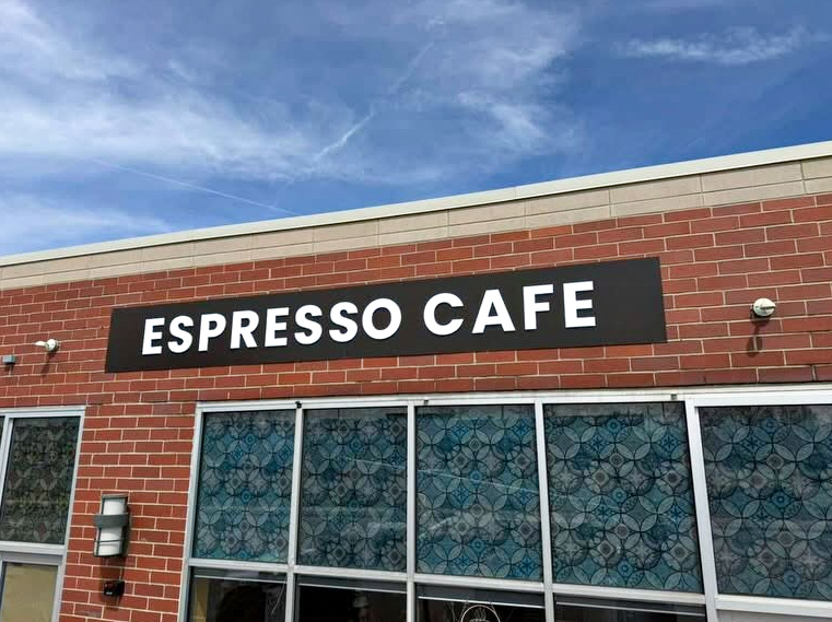 Wide daytime view of the Espresso Cafe custom storefront sign above the front windows