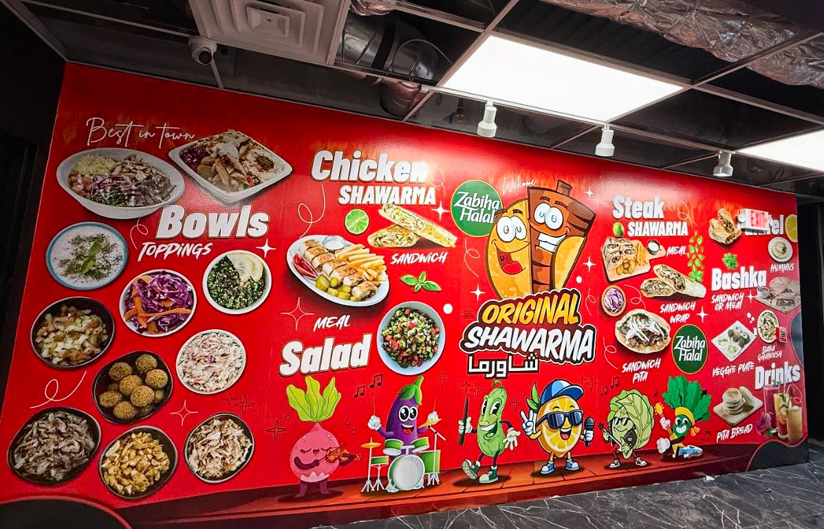 Original Shawarma restaurant interior with a large branded promotional wall graphic