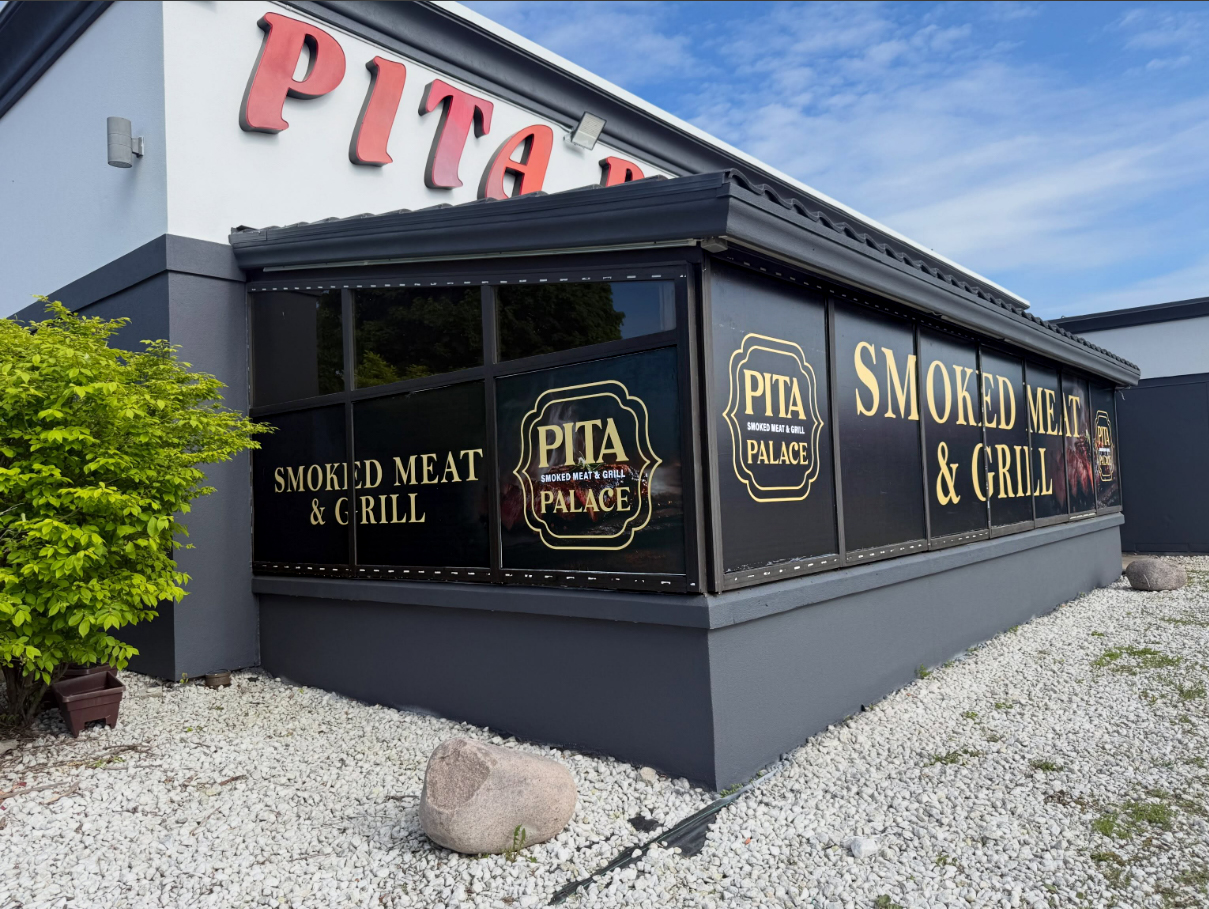 Pita Palace storefront with black and gold printed window graphics wrapping the corner windows
