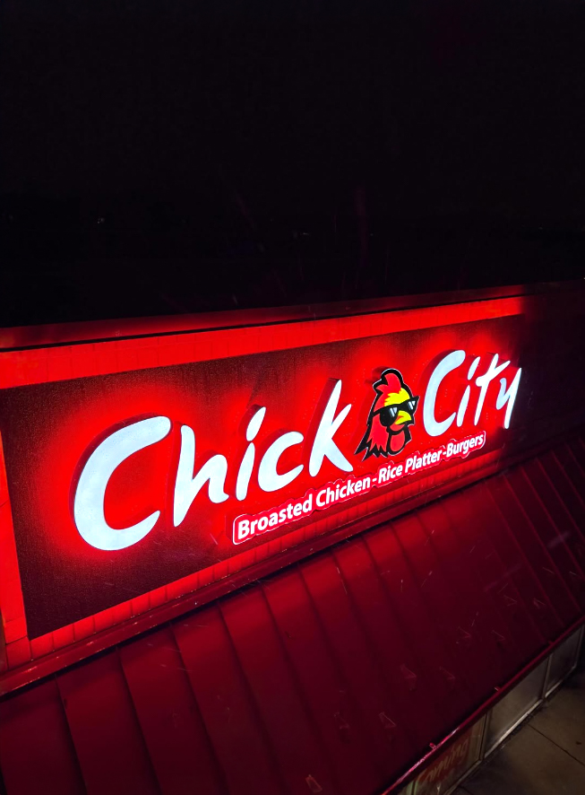 Chick City illuminated storefront sign glowing red at night