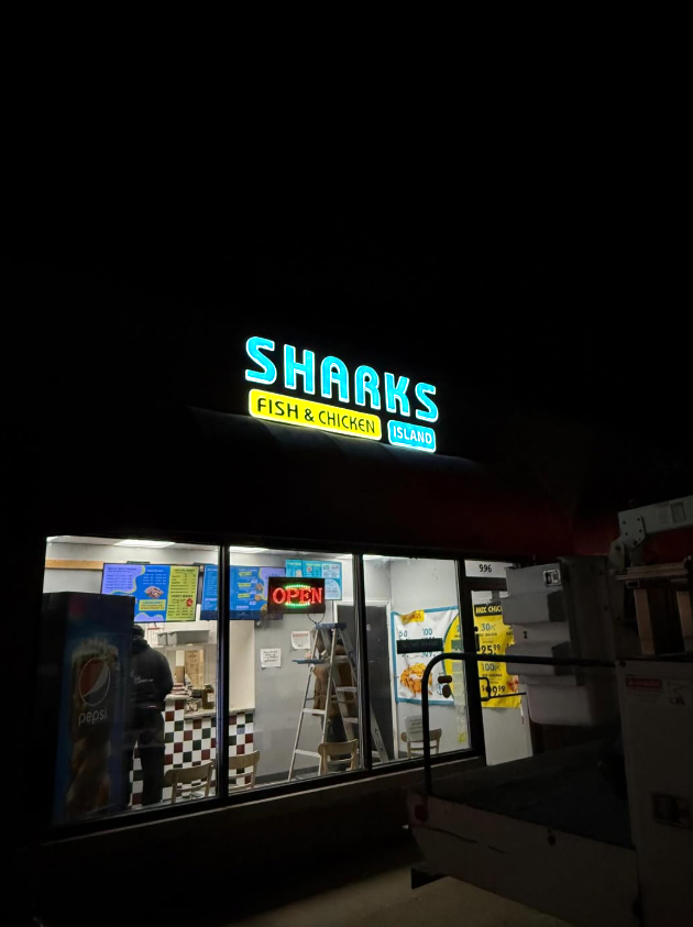 Sharks Fish and Chicken illuminated storefront sign at night