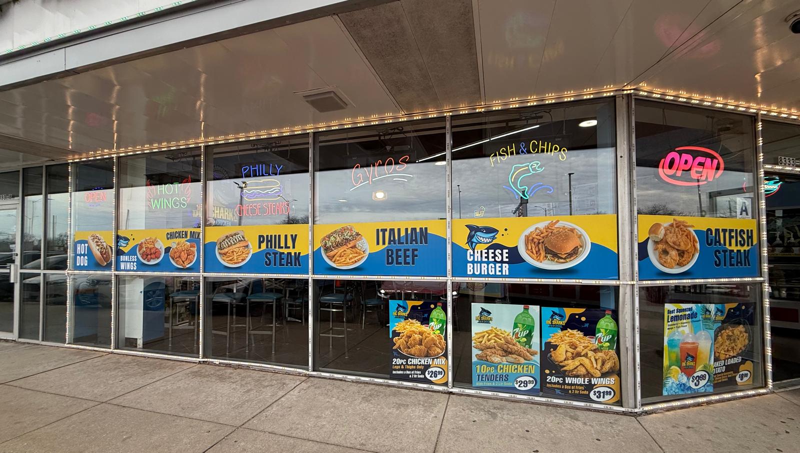 Sharks Fish and Chicken storefront with colorful food promotional window graphics
