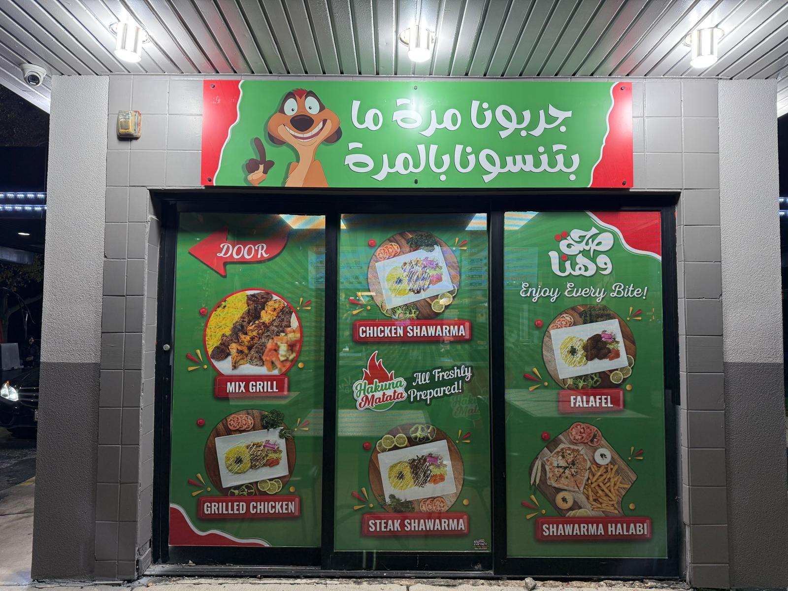 Hakuna Matata storefront with green branded food window graphics